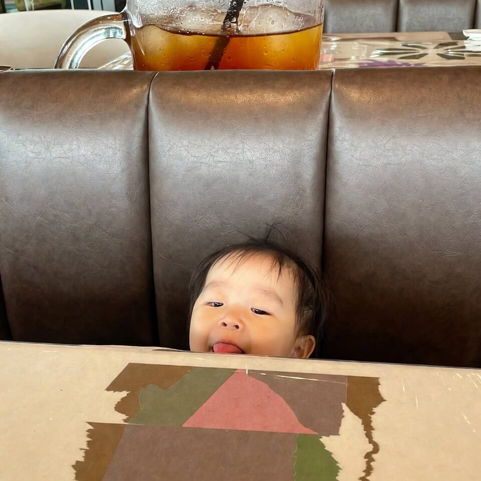 Kid sticking tongue out while coloring in booth