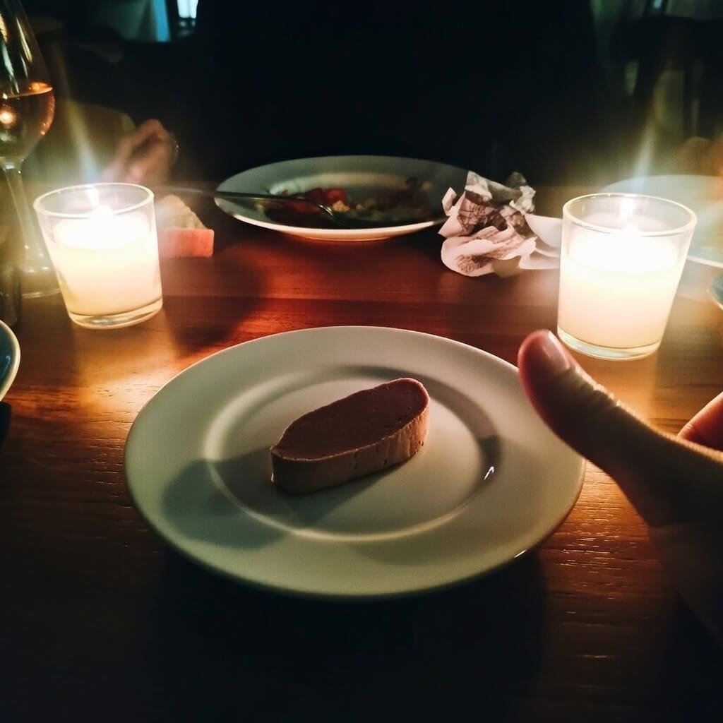 Single perfect foie gras bite, thumb accidentally in shot