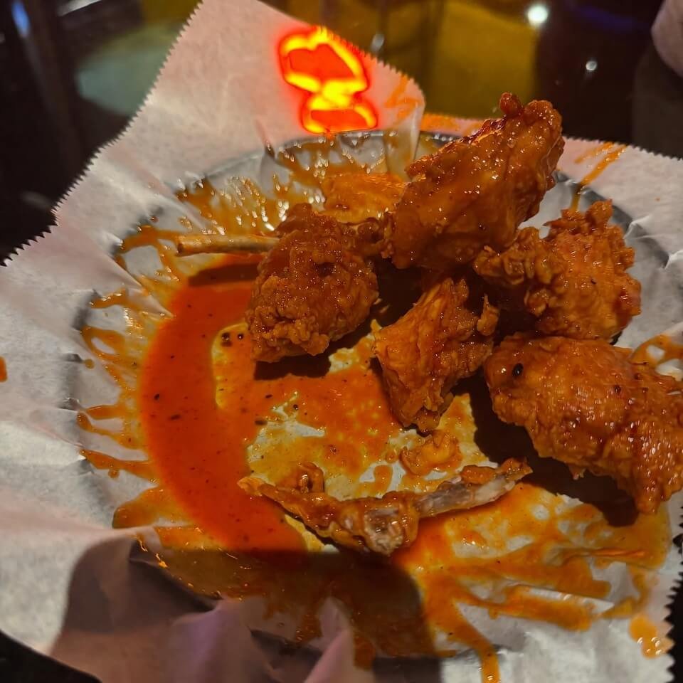 Tilted shot of half-eaten Nashville hot chicken plate